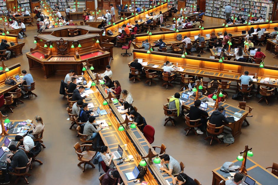 A lively university library scene with students studying diligently at wooden desks